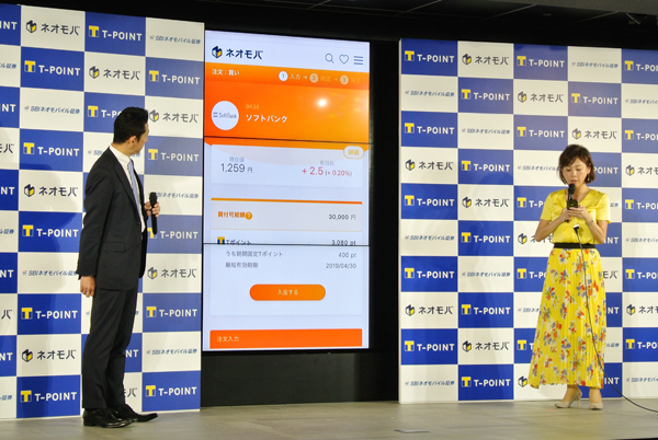 フリーアナウンサーの高橋真麻氏(右)が、SBIネオモバイル証券の小川代表の説明を受けながら、Tポイントから株式を購入